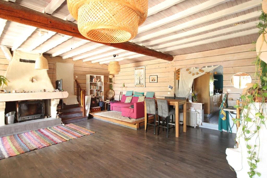 a living room with a pink couch and a fireplace at L'Abeille-Vie in Tréziers