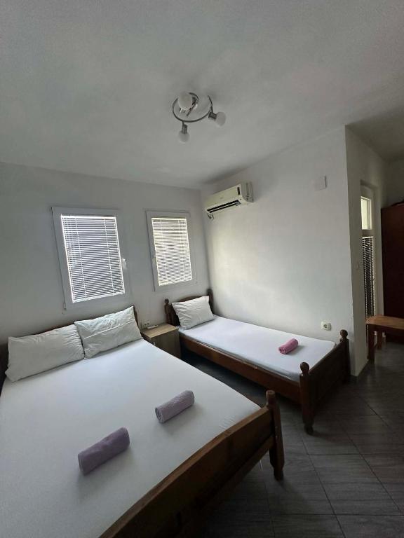 a room with two beds and two windows at Apartmani Glory Sutomore in Sutomore