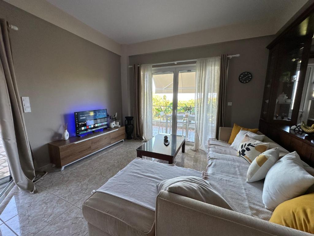 a bedroom with a bed and a couch and a television at Siamos Villa in Vonitsa