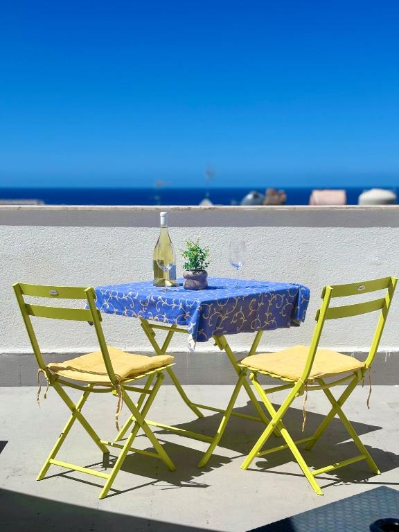 a table with two chairs and a bottle of wine at millennium holiday in Castellammare del Golfo