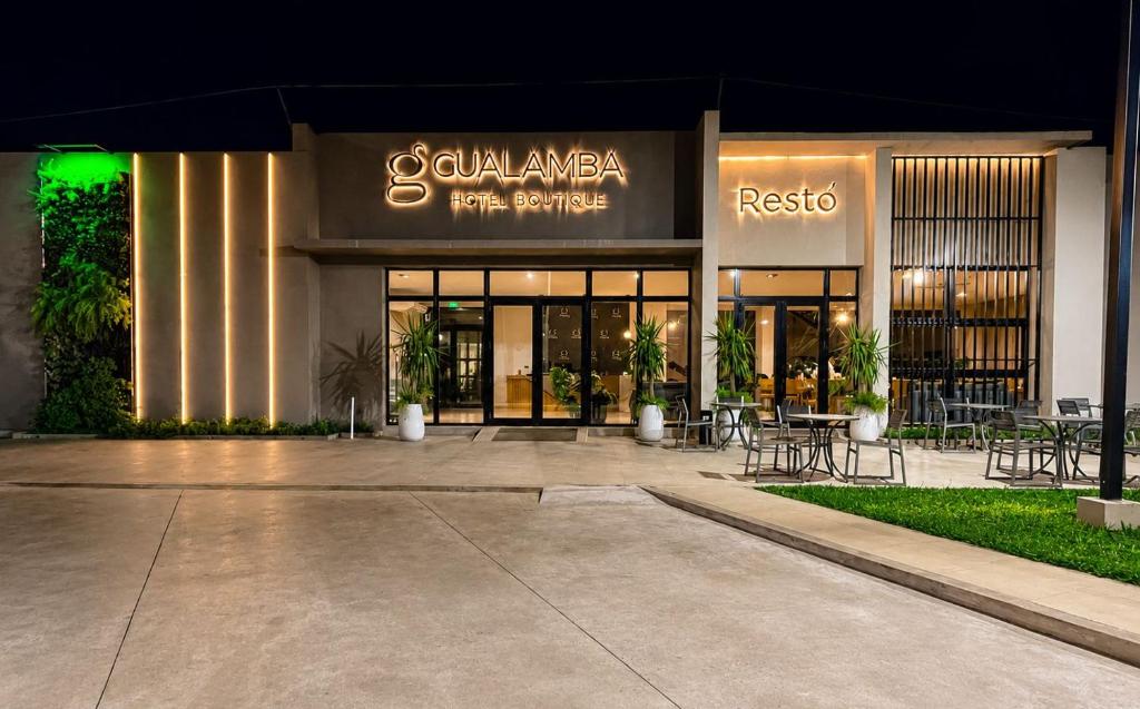 a building with tables and chairs in front of it at Hotel Boutique Gualamba in General Pinedo