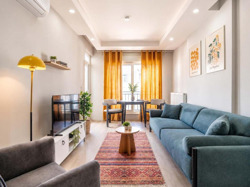 a living room with a blue couch and a table at Maxihomes Elissa in Antalya