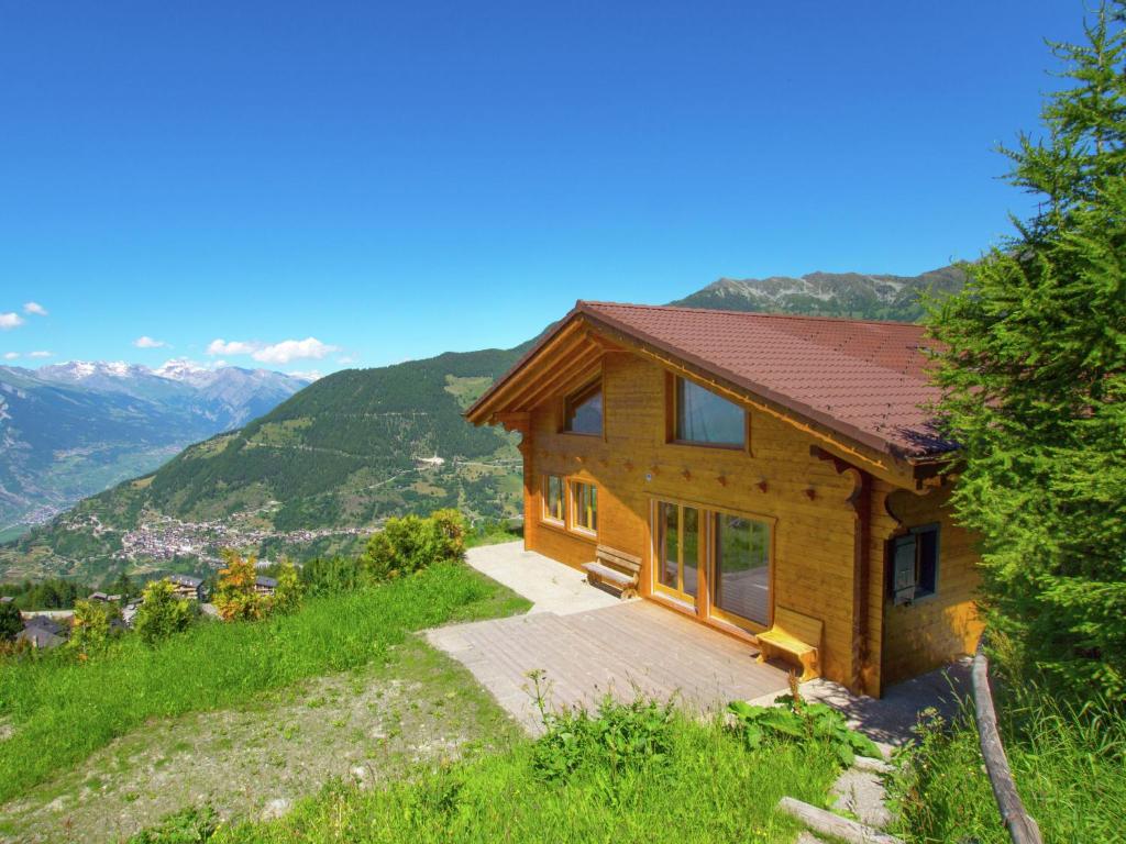 uma casa de madeira numa colina com montanhas ao fundo em Chalet Alpina offers great views em La Tzoumaz
