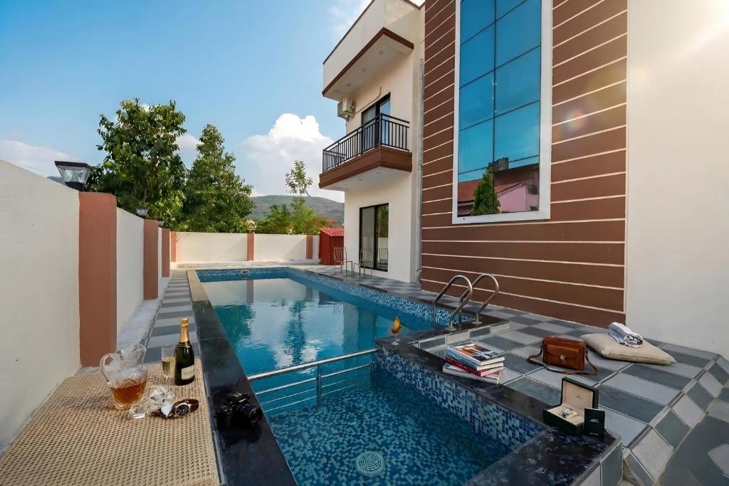 ein Swimmingpool im Hinterhof eines Hauses in der Unterkunft II EMPYREAN STAYS II SU CASA VILLA II 4BHK II AC II PRIVATE POOL Il in Lonavla