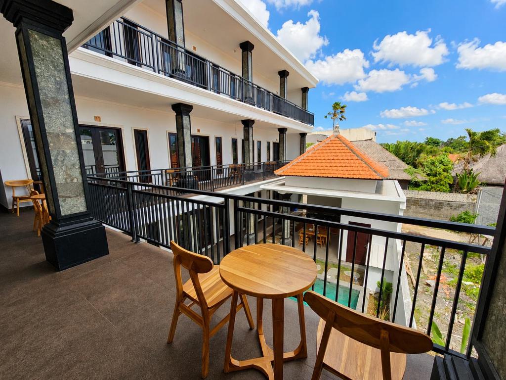 a balcony with a wooden table and two chairs at Padmasari Guest House in Canggu