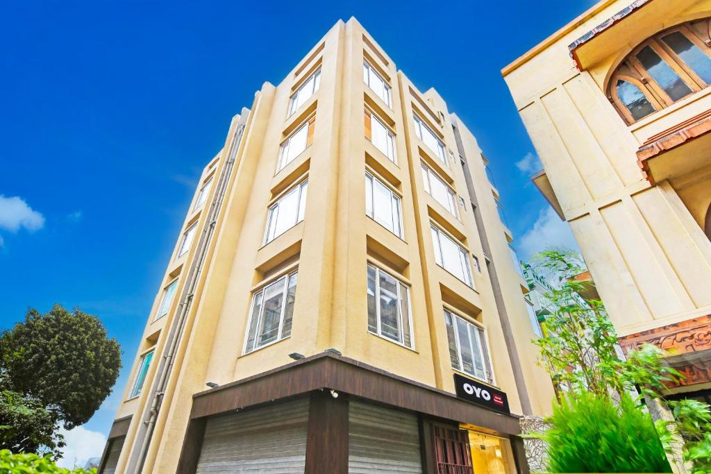 a tall yellow building with a sign on it at Super Hotel O SAMOTEL in kolkata