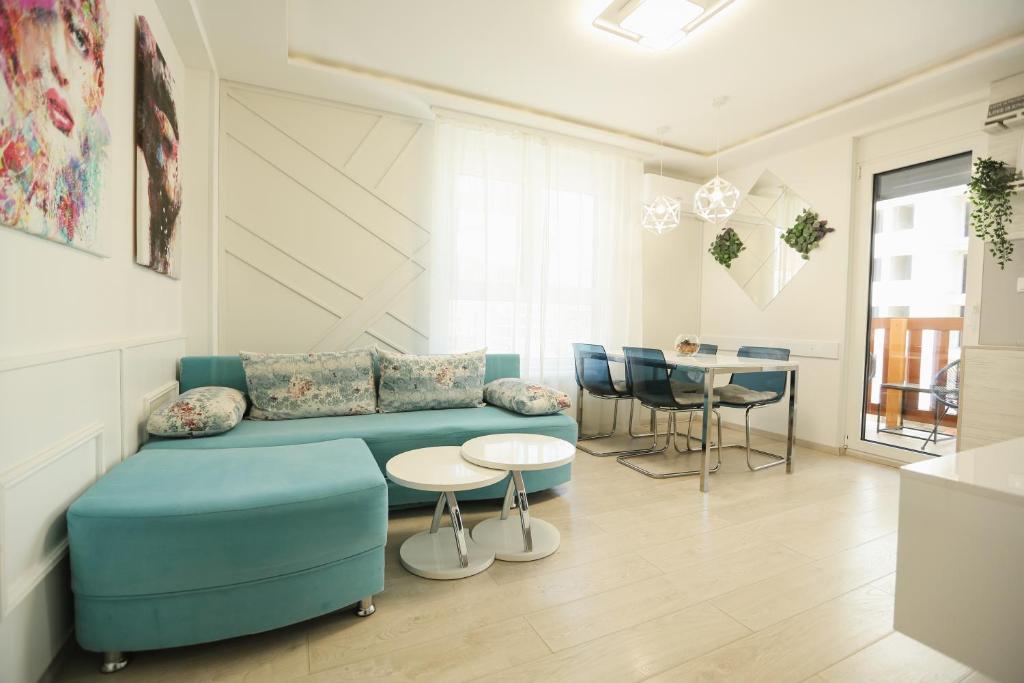 a living room with a blue couch and a table at Apartmani SLEEP&JOY in Zlatibor