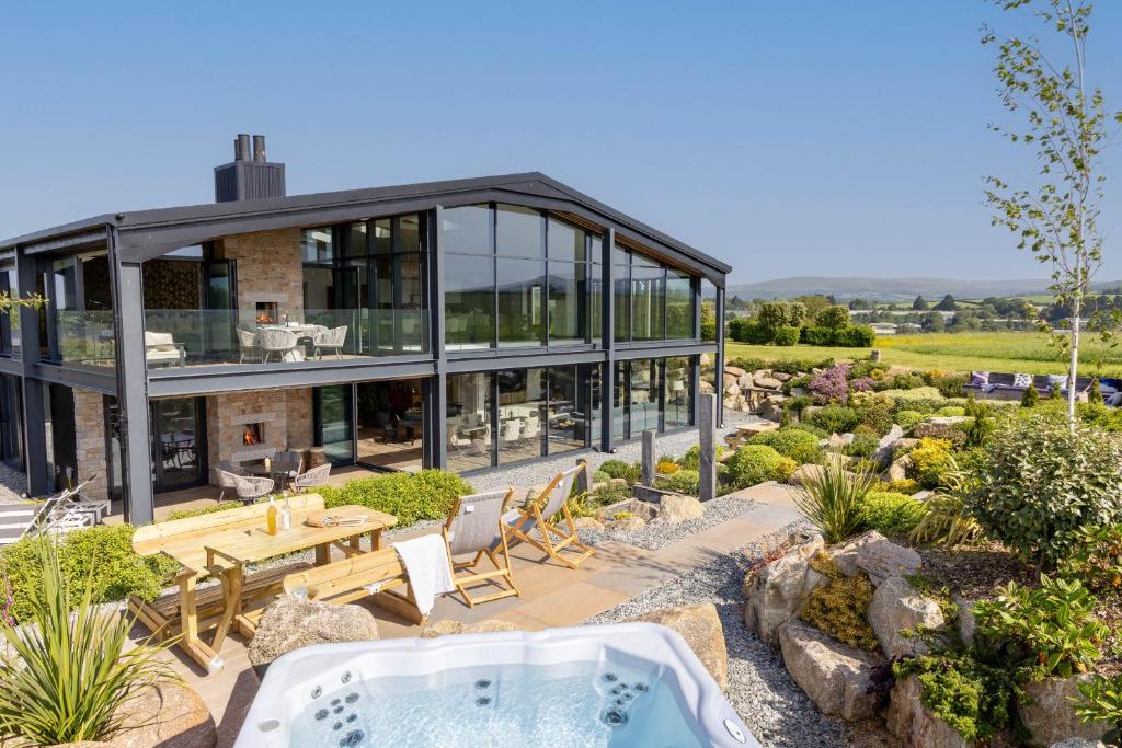 a house with a hot tub in a garden at The Retreat at Strashleigh Manor Farm - A Luxury Devon Country Escape in Ivybridge