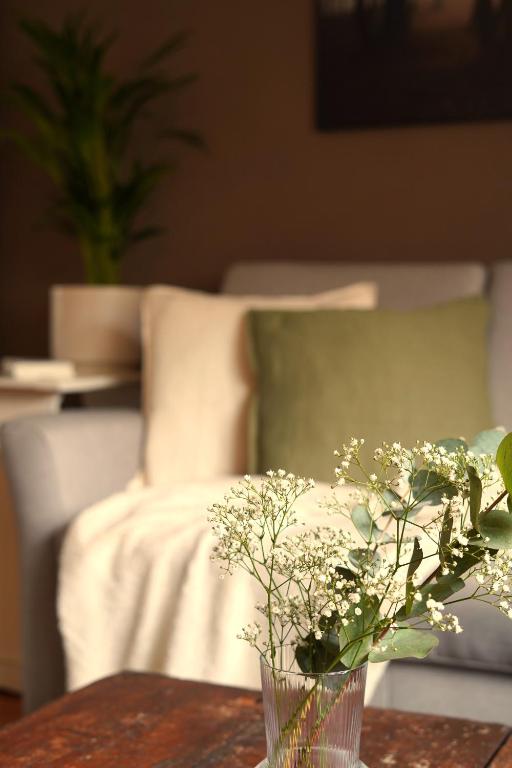 a vase with flowers on a table with a bed at Happywild in Schlangenbad
