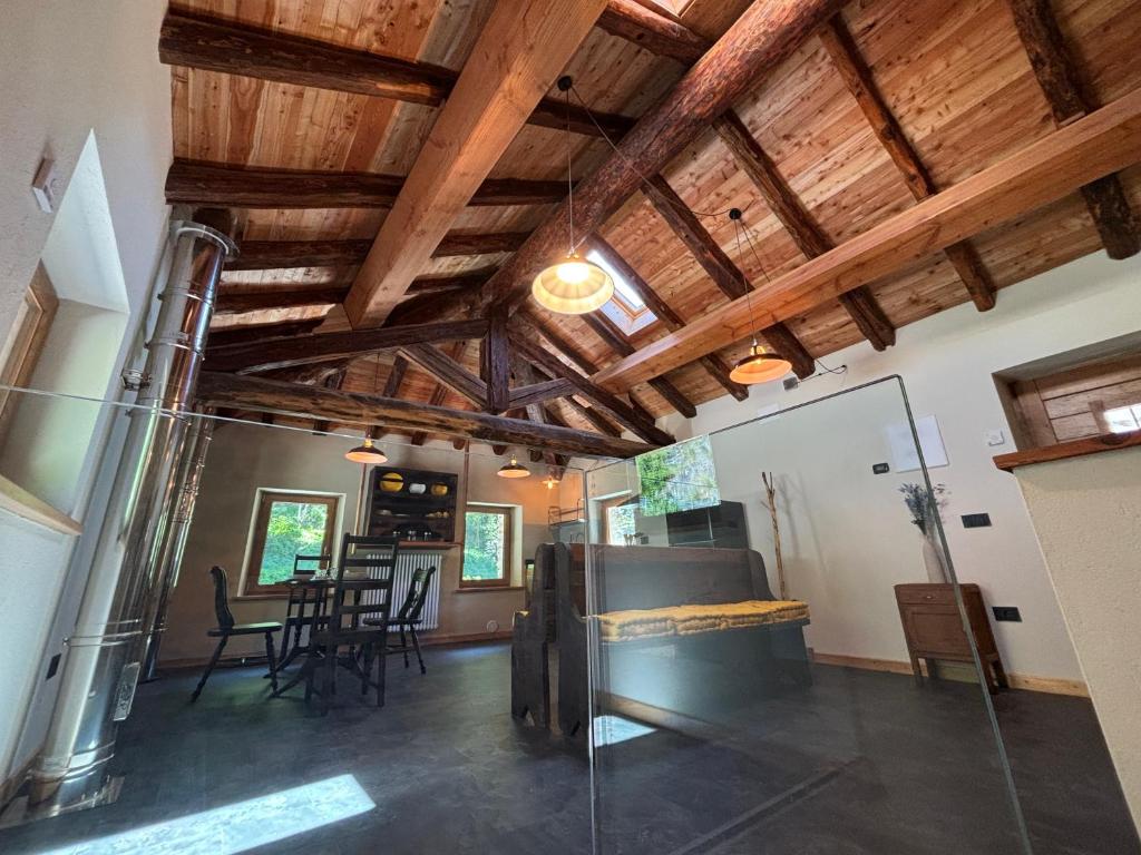 a living room with wooden ceilings and a room with chairs at Riverside Room Elia Family friendly apartment in Pontboset