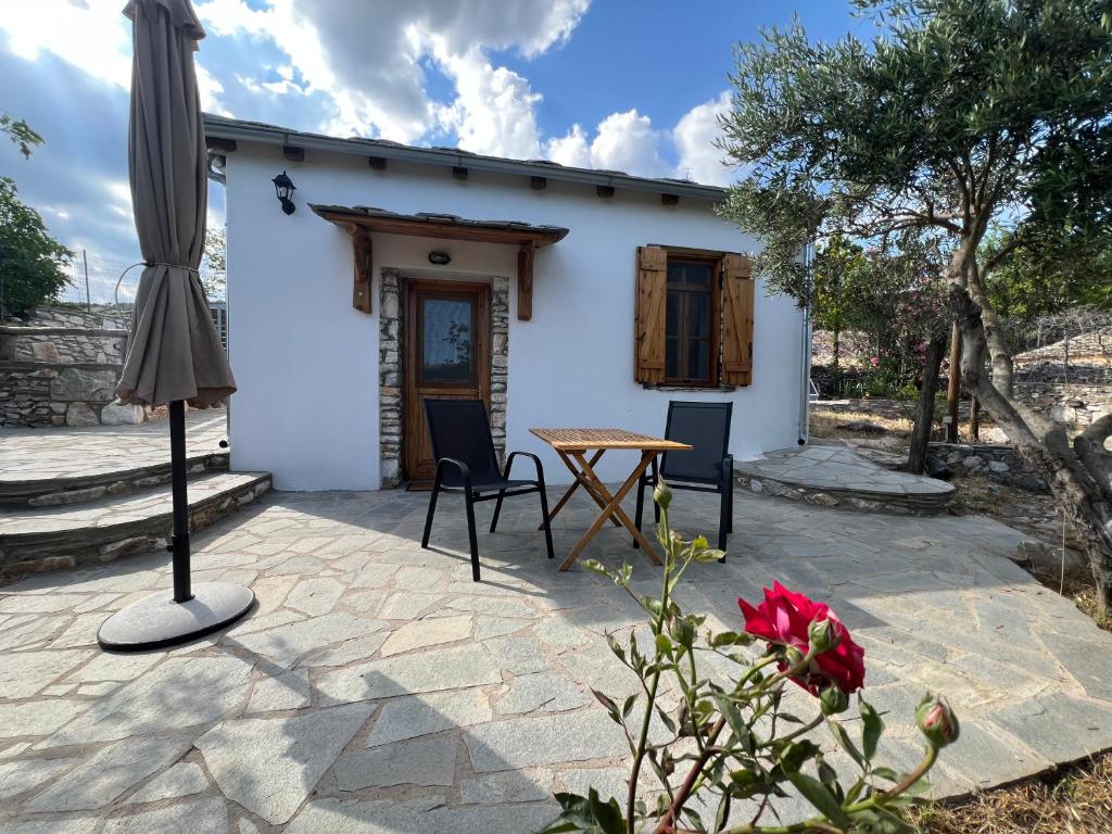 a patio with a table and an umbrella at Linos Old Barn in Theológos