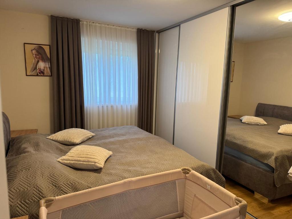 a bedroom with two beds and a large mirror at Apartman Provo in Široki Brijeg