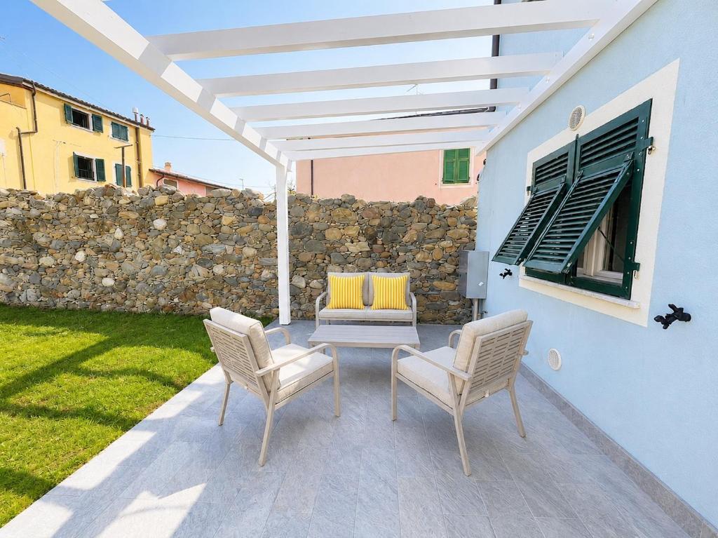 a patio with a table and chairs and a wall at Dimora San Francesco in Sarzana