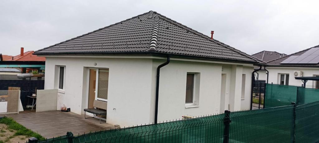 a white house with a black roof at Riverside house Duna in Rajka