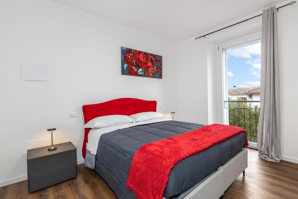 a bedroom with a bed with a red blanket and a window at Il Nido Dei Ribelli in Mergo