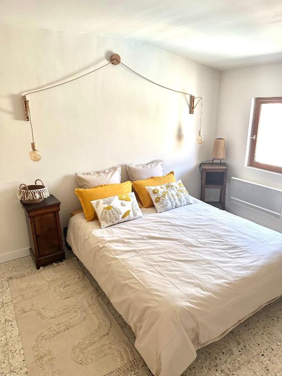 a bedroom with a large white bed with two pillows at Escapade provençale in Tarascon