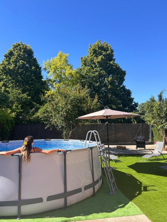 a woman is in a pool with an umbrella at Vivienda Turística Lorena in Cascante