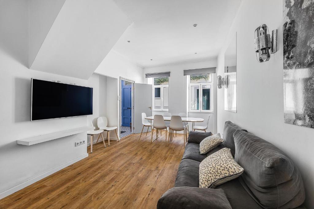 a living room with a couch and a flat screen tv at A Lodge in Blue in Aveiro