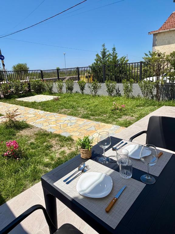 a black table with plates and wine glasses on it at Villa 3 in Velipojë