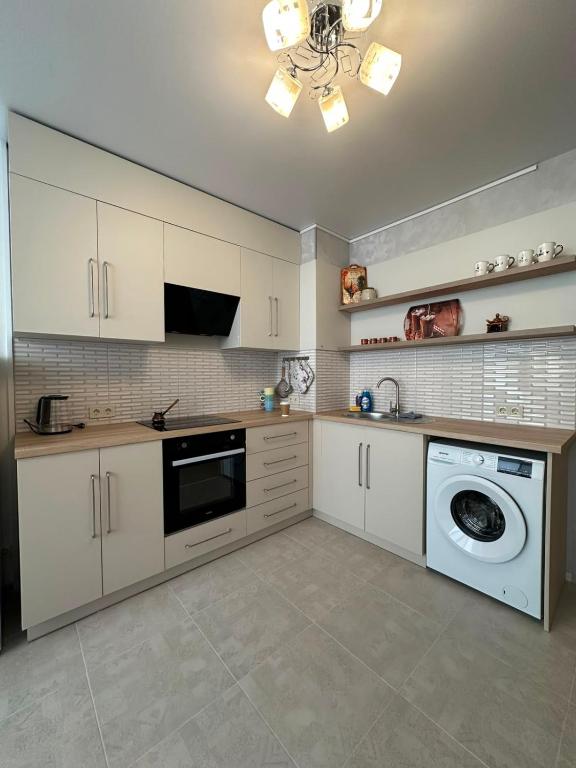 a kitchen with white cabinets and a washing machine at квартира in Odesa