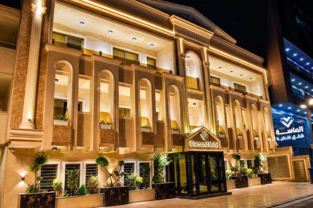 a large building with potted plants in front of it at Diamond Motel in Baghdād