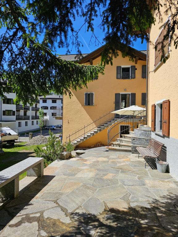 a building with benches in front of a building at Cà ai Camòss, DUPLEX deluxe - centro paese in San Bernardino