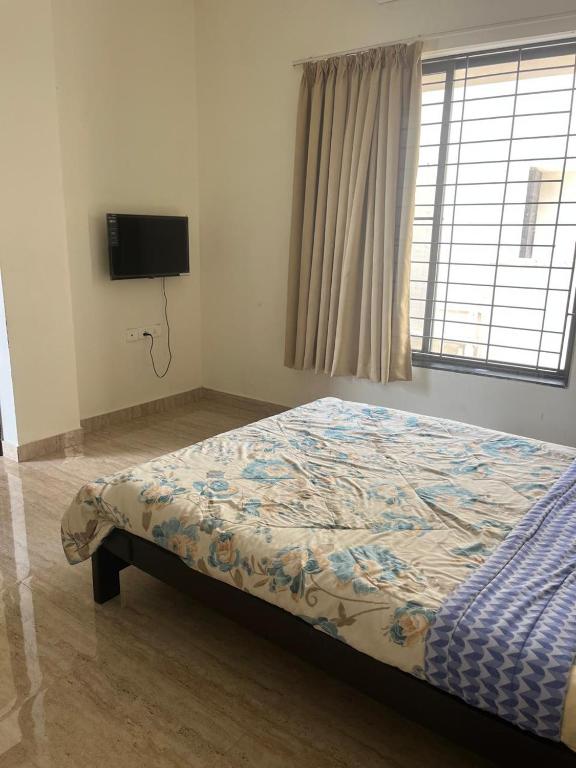 a bedroom with a bed in a room with a tv at Sai VVR homestay in Chennai