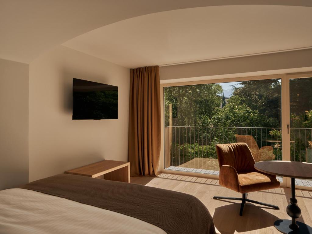 a hotel room with a bed and a balcony at Villa Giacomuzzi in Bolzano