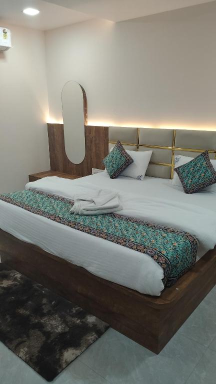 a large bed with a wooden headboard in a room at Hotel shivam comfort in Hubli