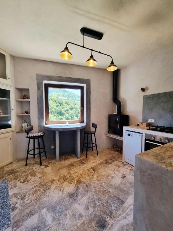 a kitchen with a table and chairs and a window at La Roccia Rossa in Stribugliano