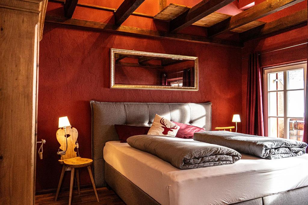 a bedroom with red walls and a bed with a guitar at Säntisblick in Oberstaufen