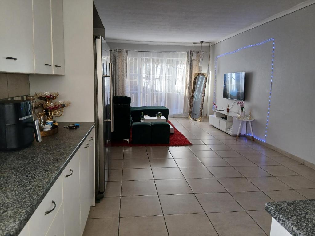a kitchen and a living room with a couch at Cousy Corner in Roodepoort
