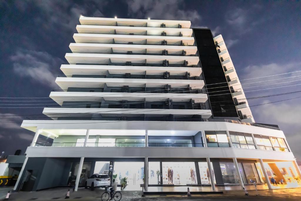 a tall white building with a lot of windows at FLORIA - Sky Suites in Accra