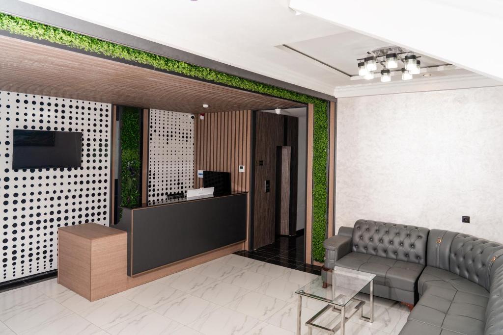 a lobby with a waiting room with a couch and a tv at Gulshan Hotel in Urganch