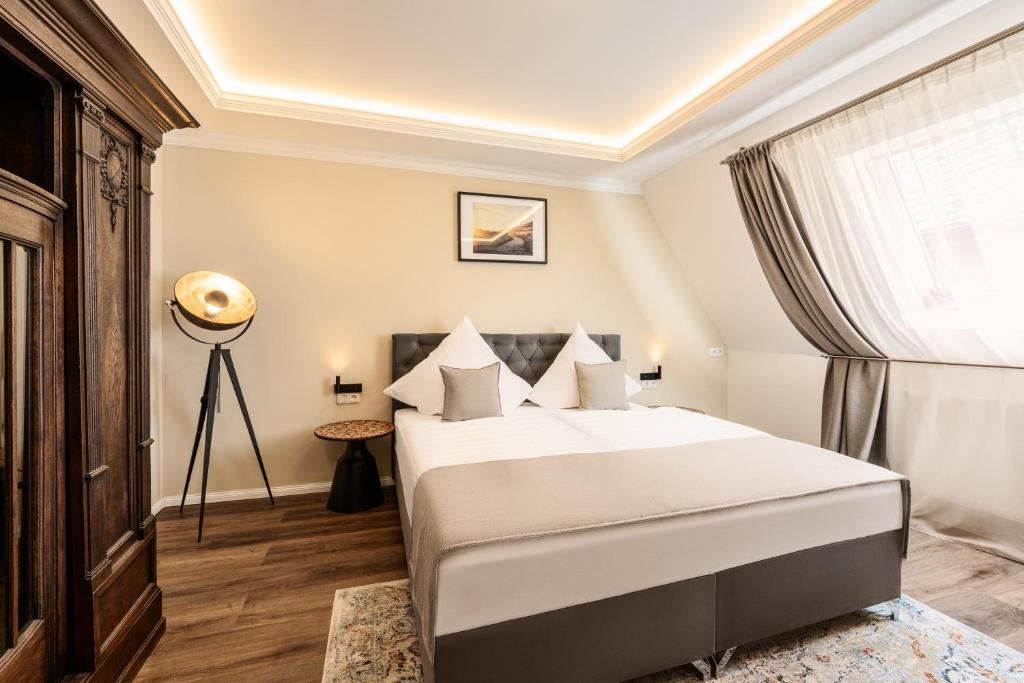 a bedroom with a large white bed and a window at Haus der Weine in Rüdesheim am Rhein