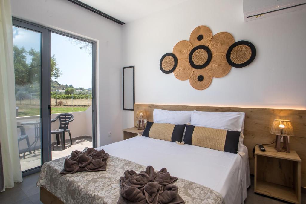 a bedroom with a bed and a large window at GK Home Studios part of GK FITNESS CLUB in Faliraki