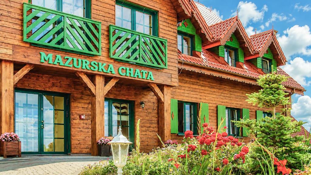 a building with a sign on the side of it at Mazurska Chata jezioro i aquapark 6 min, centrum i promenada 12 min in Mikołajki