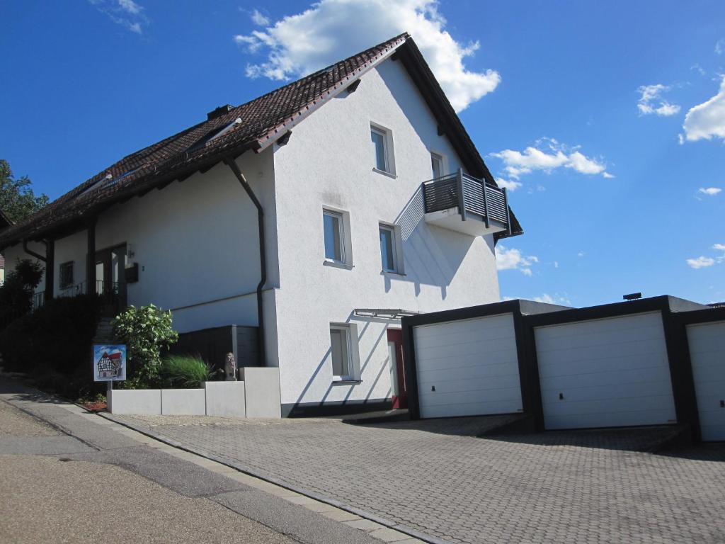 a white house with two white garage doors at Appartementhaus Zur schönen Aussicht in Bad Abbach
