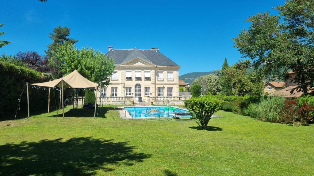 a large house with a swimming pool in a yard at Chambres d hôtes dans maison bourgeoise Douce France in Millau