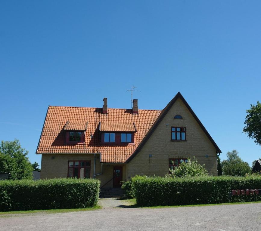 a house with a red roof and some bushes at Lilla Skolhuset i Ingelsträde in Höganäs