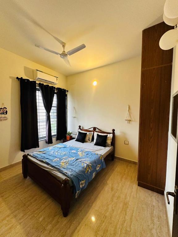 a bedroom with a bed and a ceiling fan at Coastal villa in Tirupporūr