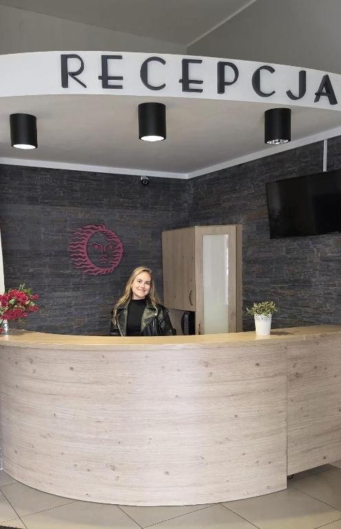 a woman standing behind a counter in a restaurant at Vacation Club Łeba in Łeba