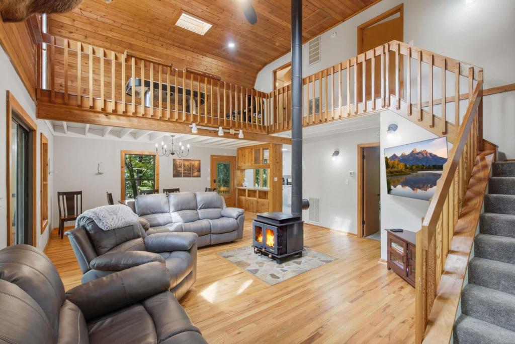 a living room with a staircase and a fireplace at Sharp Top Mountain Retreat in Jasper
