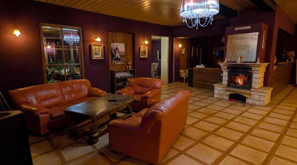 a living room with leather furniture and a fireplace at 7Rooms in Telnice