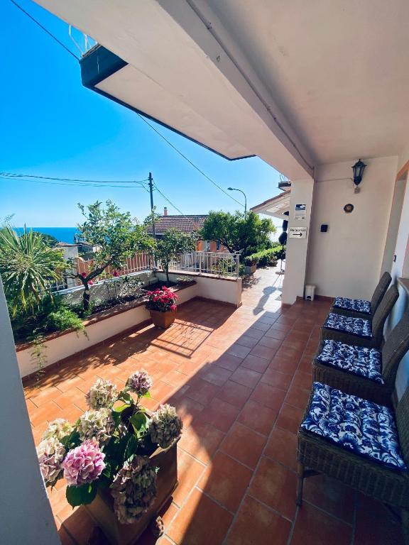 a balcony with couches and potted plants and the ocean at B&B Villa Rosa Angrisano in Maratea