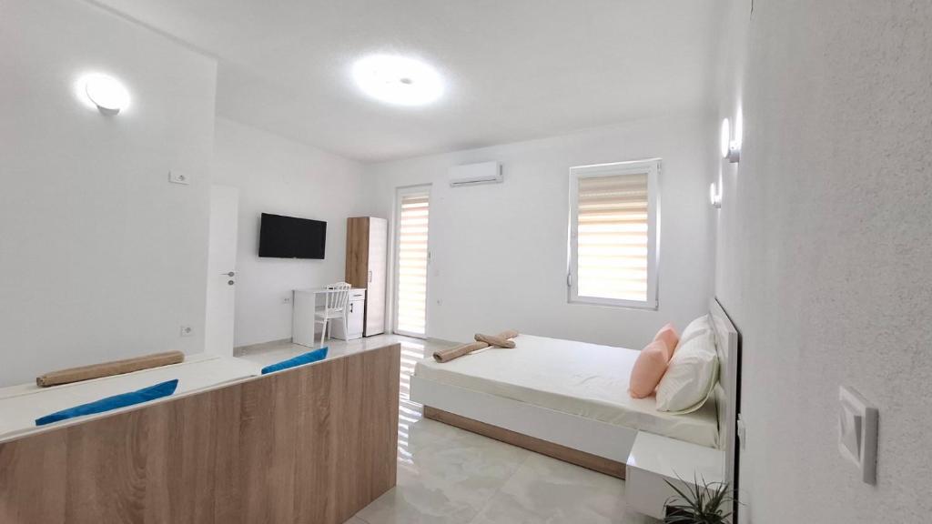 a white room with a bed and a tv at Apartments BIA in Gevgelija