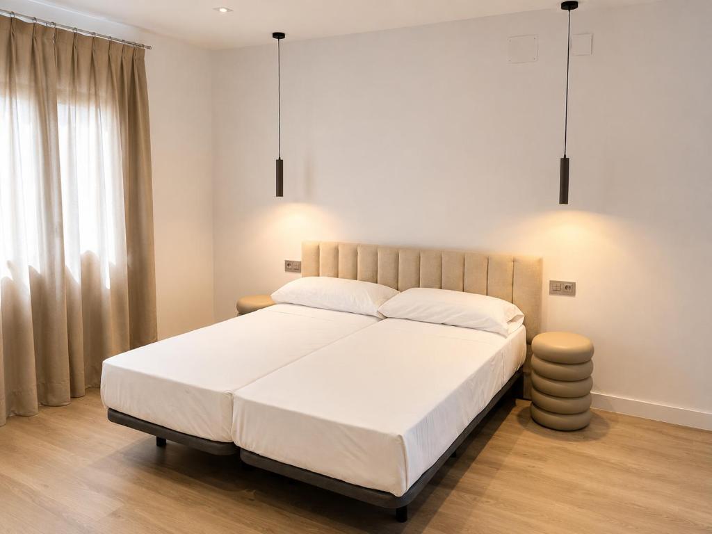 a bedroom with a large white bed with two pillows at Arena House Conil in Conil de la Frontera