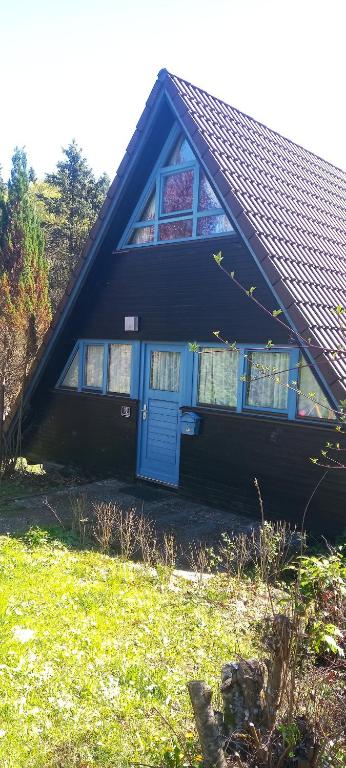 a black house with a blue door and windows at Ferienpark Vorauf Typ B/Oslo Wacholderweg 10 in Siegsdorf