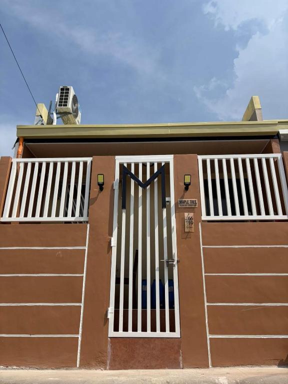 a house with a garage door with a gate at Maple Tree by The Guild Oasis Transient House in Rosario
