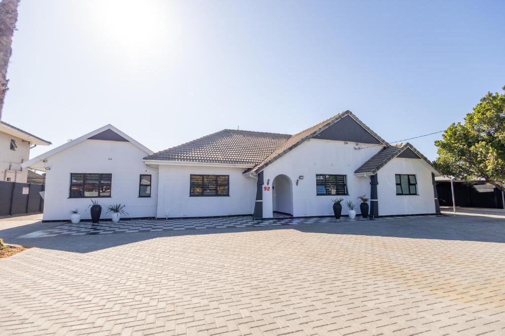 a white house with a driveway in front of it at Dazzle Stay in East London